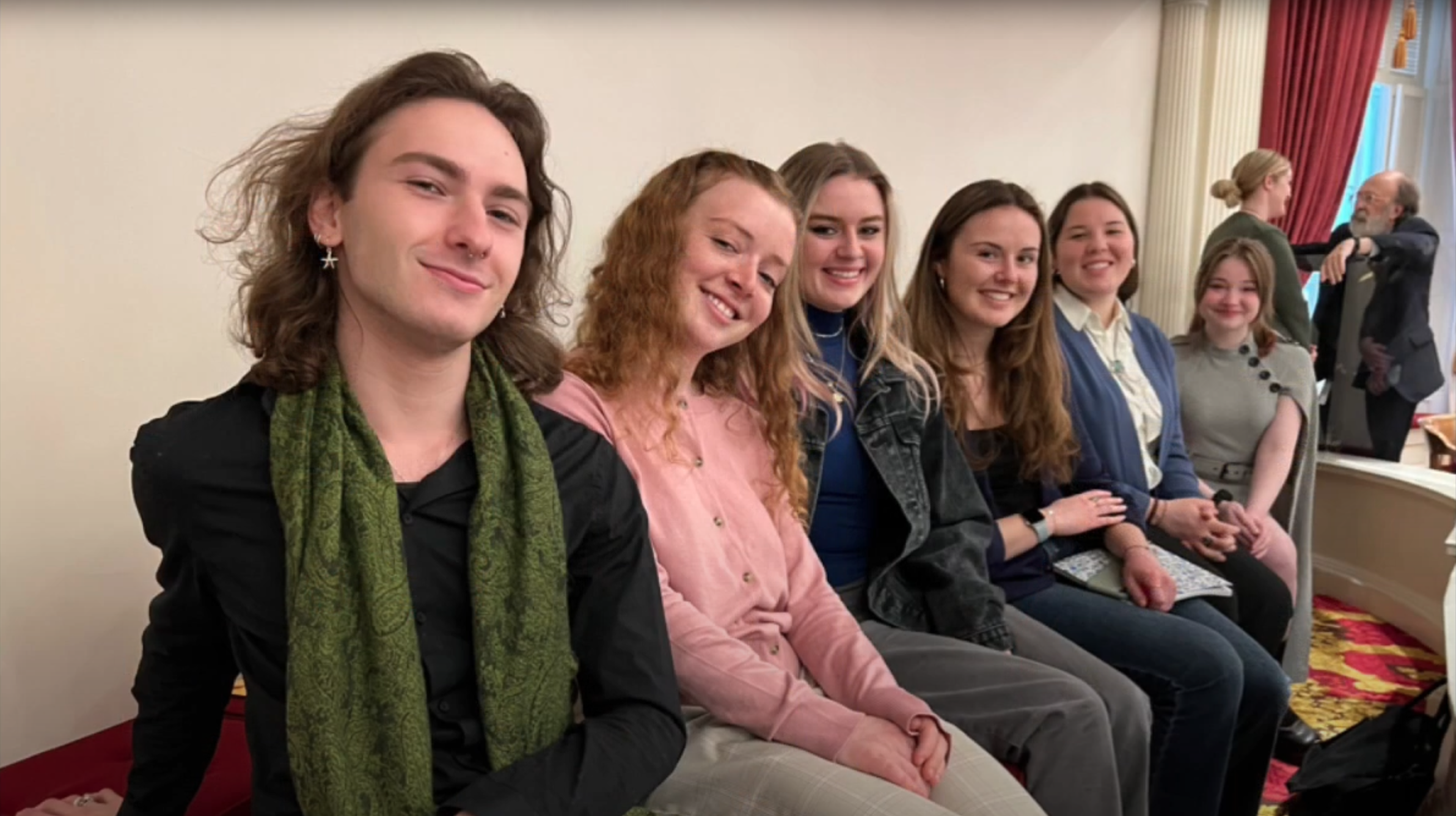 A group of young survivors sit in a row, smiling for the camera
